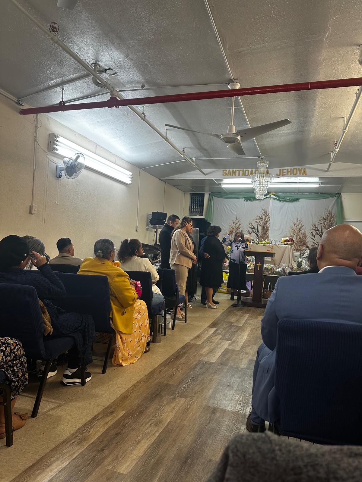 Hermanos reunidos en un culto de adoración bajo el lema Santidad a Jehová